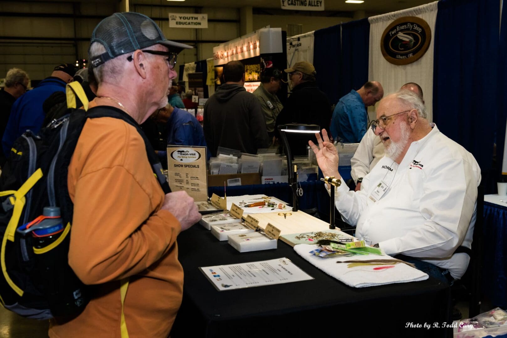 A man and woman at an event talking to each other.