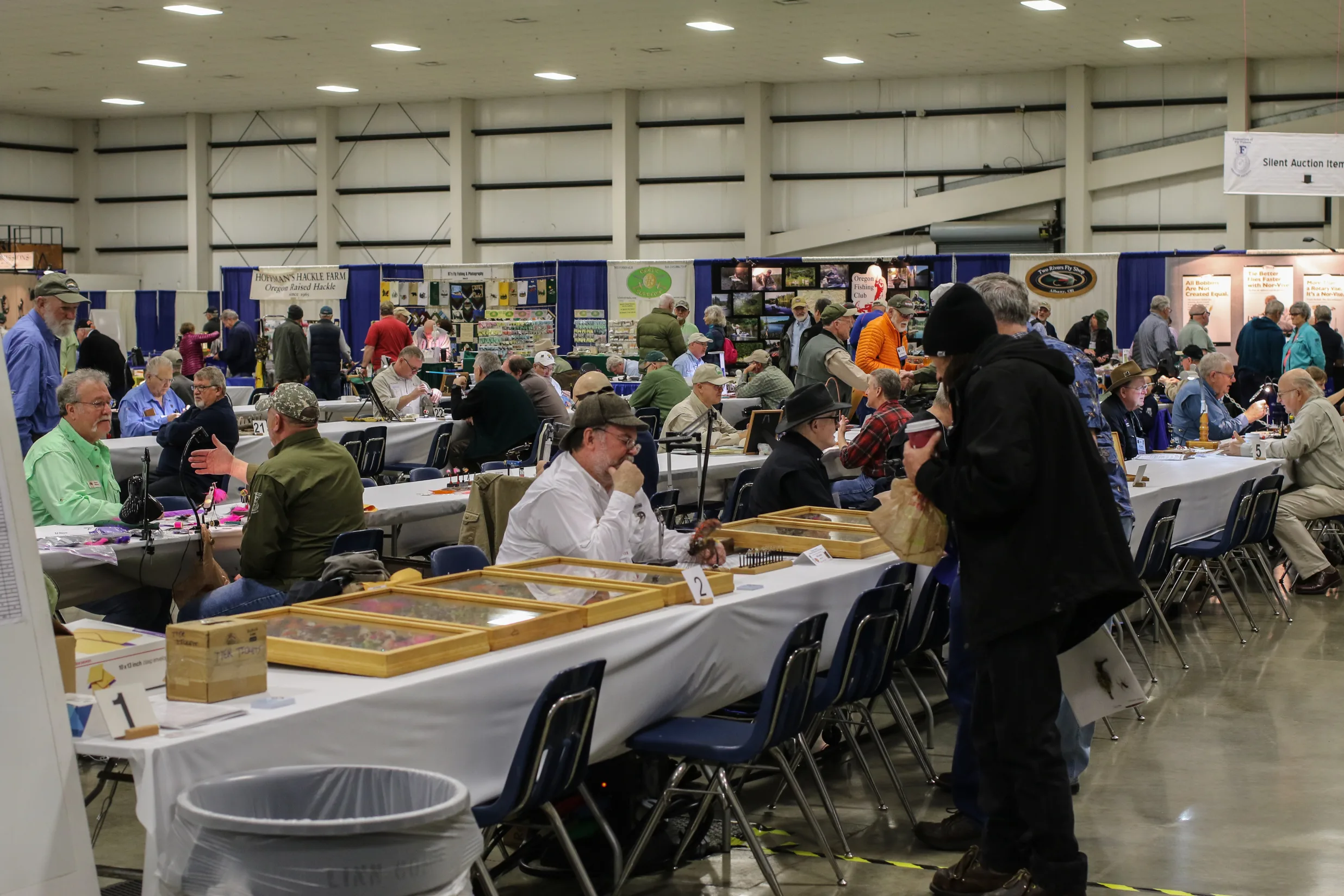 A group of people sitting at tables with boxes.